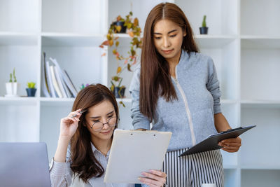 Portrait of smiling young woman using digital tablet at home