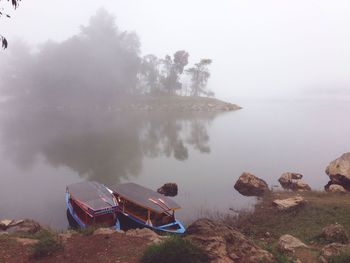 Scenic view of lake against sky during foggy weather