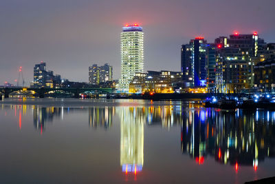 Illuminated buildings in city against sky at night