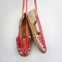 Close-up of shoes handing on white wall