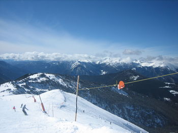Ski lift over snowcapped mountains against sky
