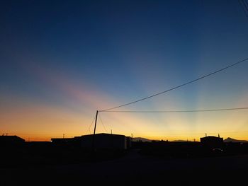 Silhouette city against sky during sunset