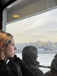 Side view of man standing in car