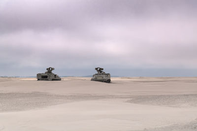 2 army vehicles on the beach tanks