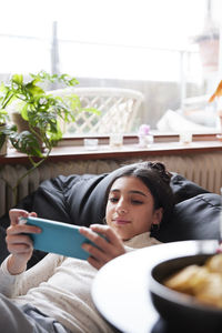 Girl lying on bean bag and playing video games