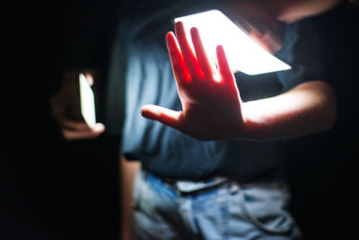 Close-up of human hand on illuminated mirror