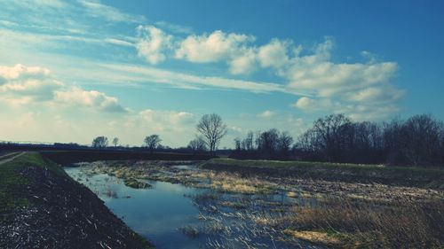 Scenic view of field against cloudy sky