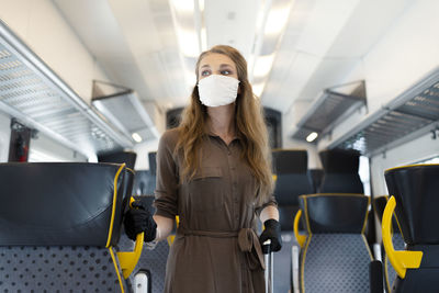 Full length of woman standing in train