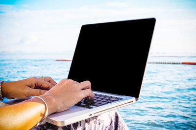 Woman using laptop at beach