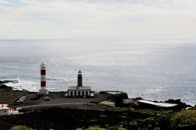 High angle view of lighthouse by sea against sky