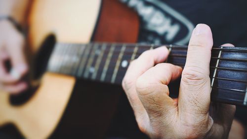 Close-up of person hand playing guitar