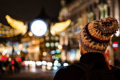 Rear view of man in city at night
