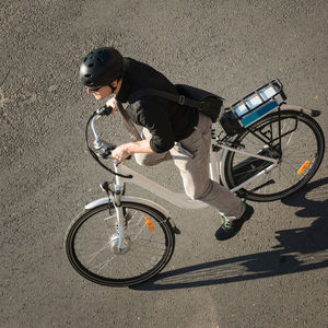 High angle view of businessman riding bicycle on road