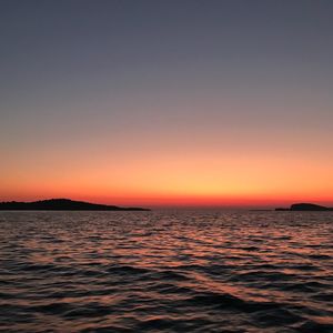 Scenic view of sea against clear orange sky