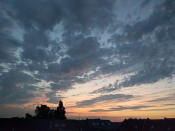 Silhouette of city against dramatic sky