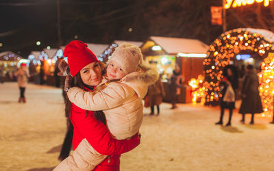 Portrait of mother and daughter standing outdoors