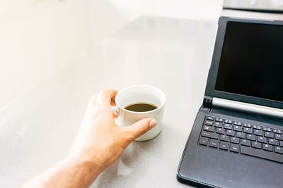 Midsection of coffee cup on table