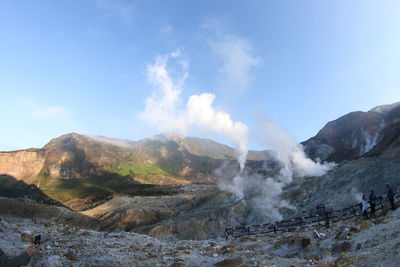 Smoke emitting from volcanic mountain against sky