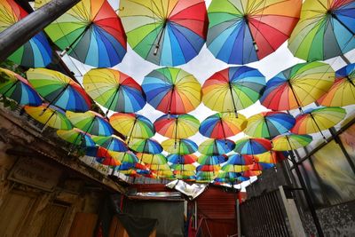 Low angle view of multi colored umbrellas hanging on roof