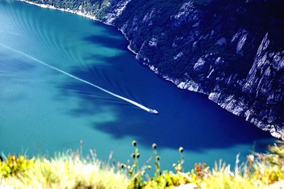 High angle view of boat in river by mountain during sunny day