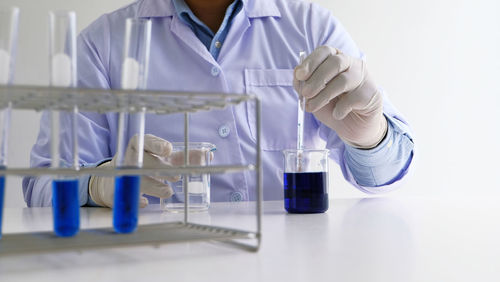 Midsection of scientist working in laboratory