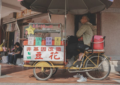 Rear view of people cycling on street