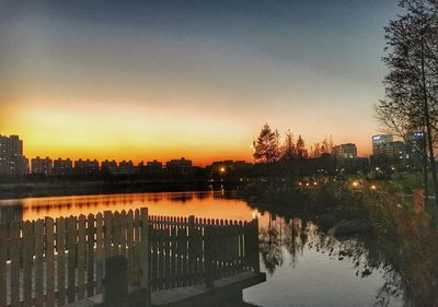 Reflection of trees in water at sunset