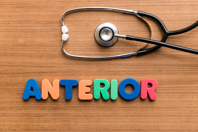 High angle view of stethoscope with colorful text on wooden table