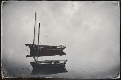 Side view of fishing boat moored in sea against sky