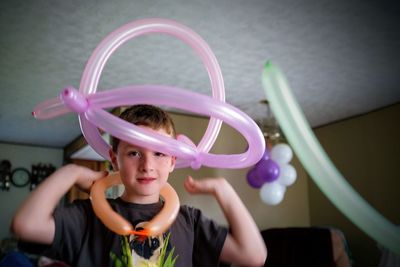 Portrait of boy holding balloons at home