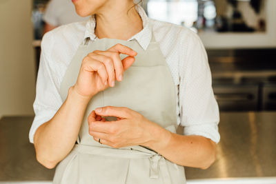 Hands of female non recognisable chef wearing an apron