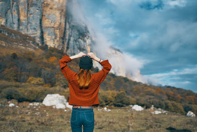 Rear view of person photographing against mountain range
