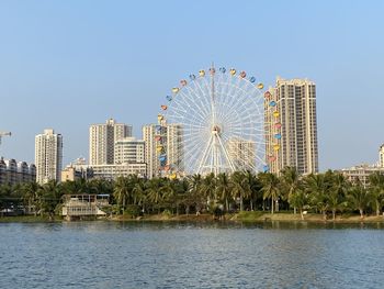 Ferris wheel by buildings against sky