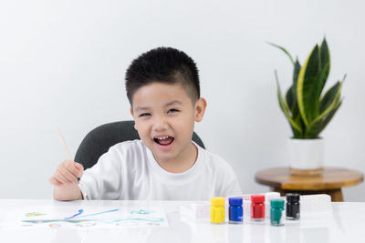 Portrait of cute boy holding table