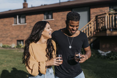 Full length of a smiling young man drinking glass