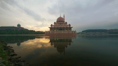 Reflection of mosque in lake against sky
