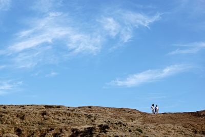 People standing on land against sky