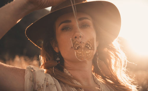 Close-up portrait of young woman wearing hat