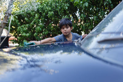 Child washing a car in the garden