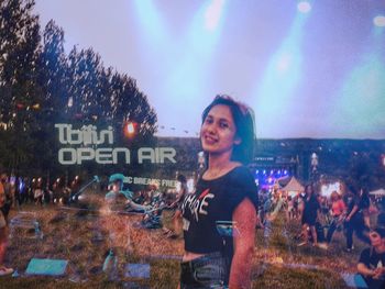 Woman standing on illuminated city at night