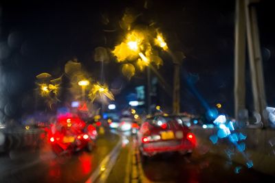 Illuminated cars on road in city at night