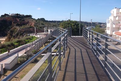 Steps leading towards footbridge against sky