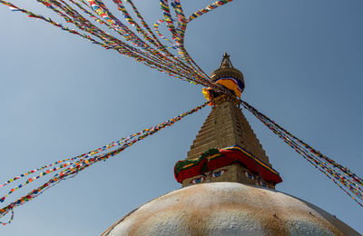 Boudha stupa, at kathmandu city in nepal against blue sky, with religious colorful flags waving.