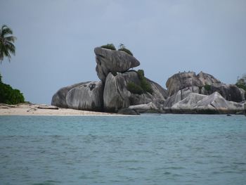 Rock formations in sea against sky