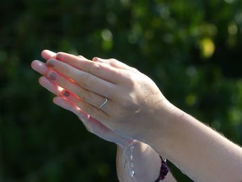 Cropped hands of woman splashing water outdoors