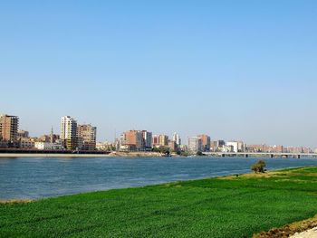 Sea and buildings against clear sky