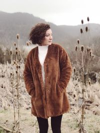 Young woman standing on field during winter