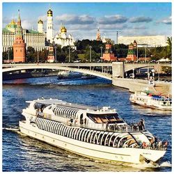 Boats in river with city in background