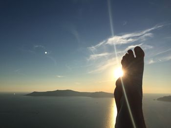 Silhouette woman against bright sun during sunset