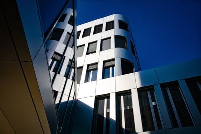 Low angle view of modern building against clear blue sky